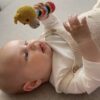 Baby is aan het spelen met de rammelaar giraffe van global affairs